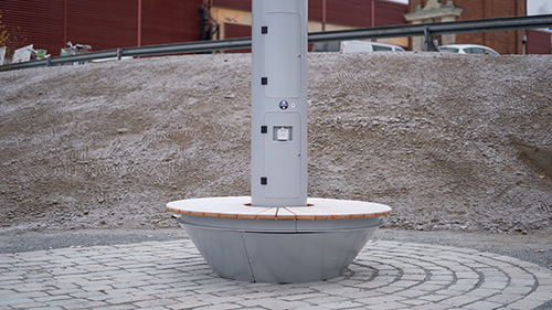 At the base of the smart pole there is a bench for resting and a charging point for visitors in the park.